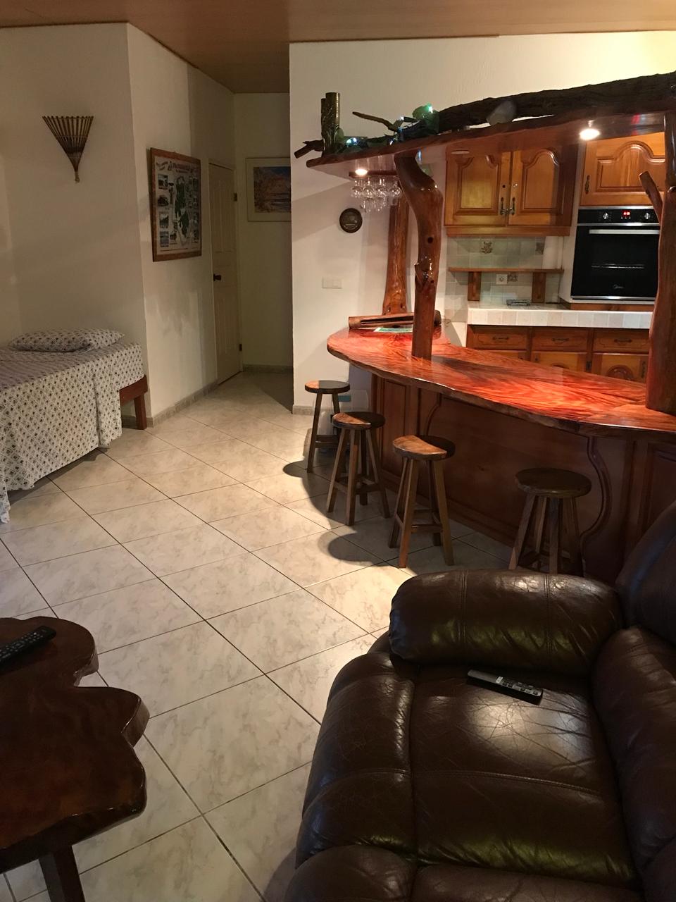 Salon confortable avec bar en bois du Fare Manino - Séjour authentique Huahine îles Sous-le-Vent