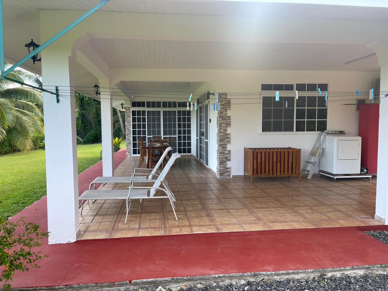 Terrasse couverte du Fare Manino avec vue jardin tropical - Hébergement Huahine lagon turquoise
